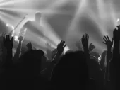 A line of hands raised at a music gig.