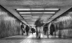 Long exposure photo of people walking through an underpass, their figures blurry and ghostly.
