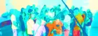 A group of people stand around in a huddle, with the photograph colour-shifted to be immensely turquoise.